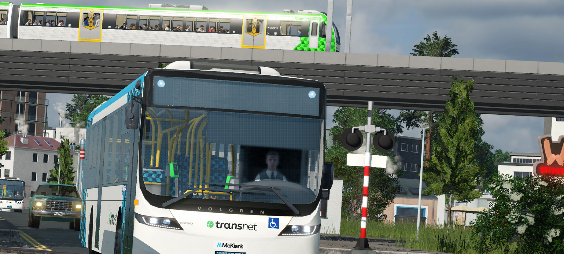 Image of a Transnet liveried McKian's bus passing the Bradfield Sidings Level Crossing, with an overhead shot of a B set